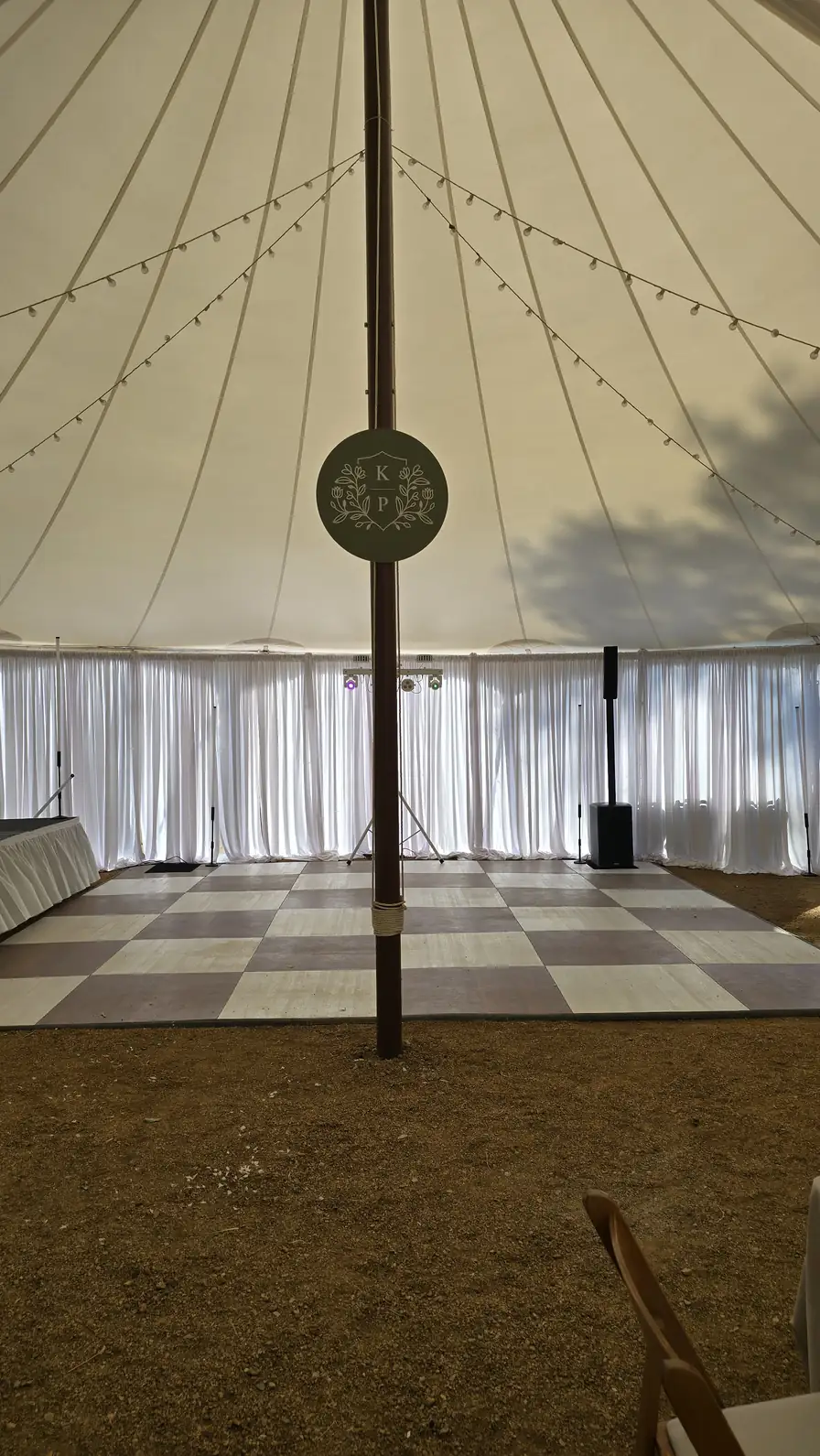 Sheer white drape walls inside the pole tent behind the dance floor