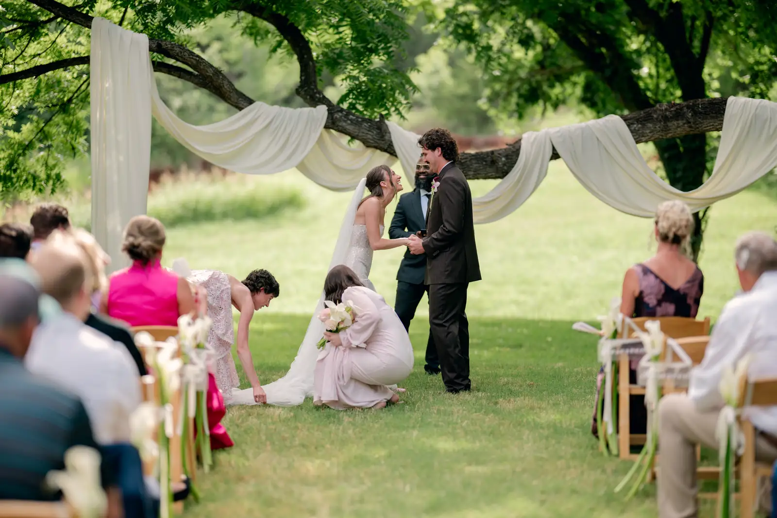 Guests watch the ceremony under the swagged tree line
