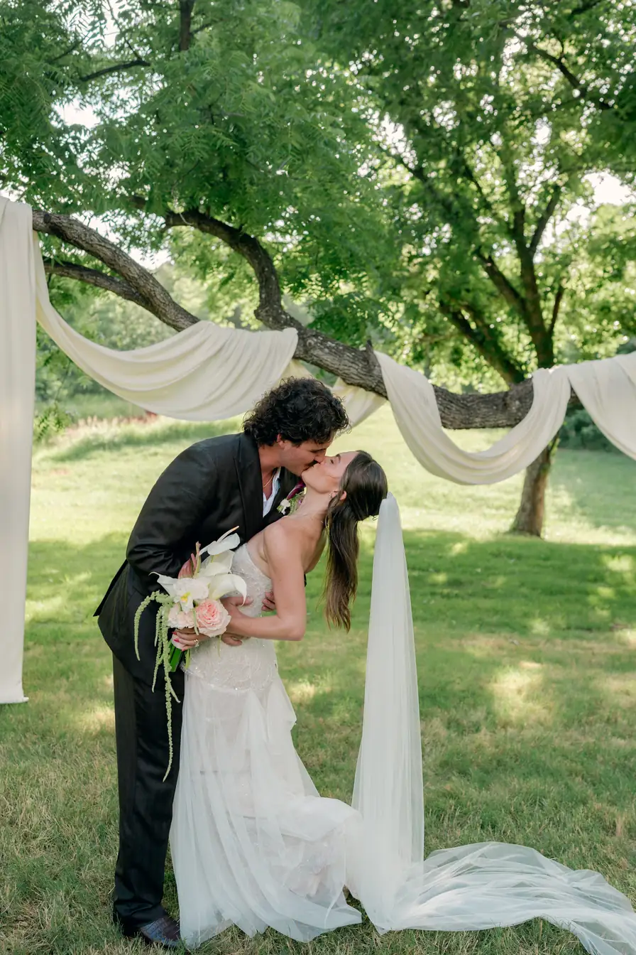 A kiss under the ivory swags after the vows