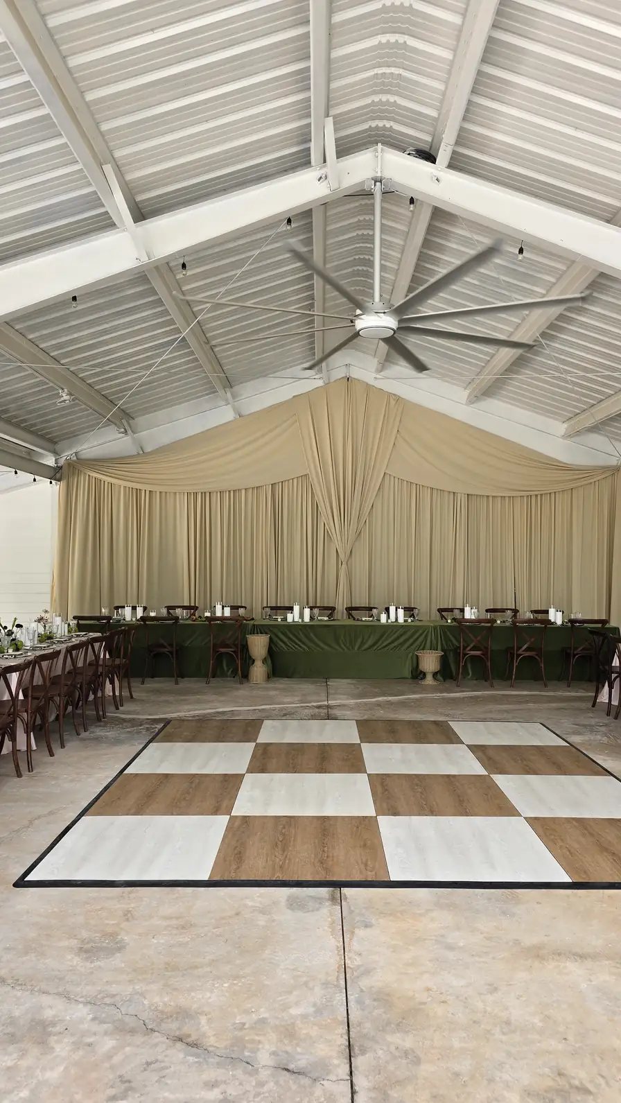 The pavilion before doors: cream drape wall, head table and checkered floor